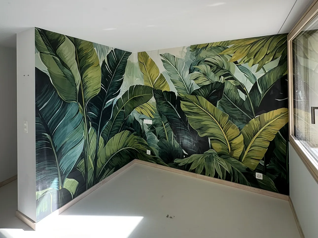 Papier peint panoramique à feuilles tropicales posé dans une chambre – décoration intérieure à Nyon
